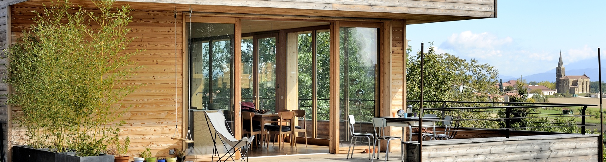 Maison ossature bois avec terrasse, menuiseries bois, baies vitrées bois